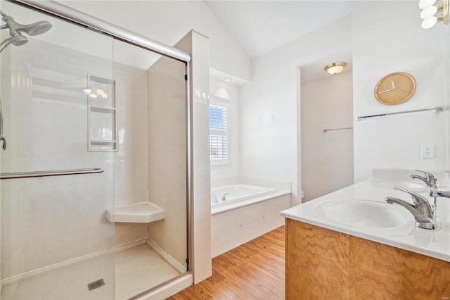 bathroom featuring vaulted ceiling, wood-type flooring, plus walk in shower, and vanity