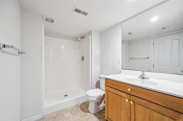 bathroom featuring toilet, vanity, and a shower