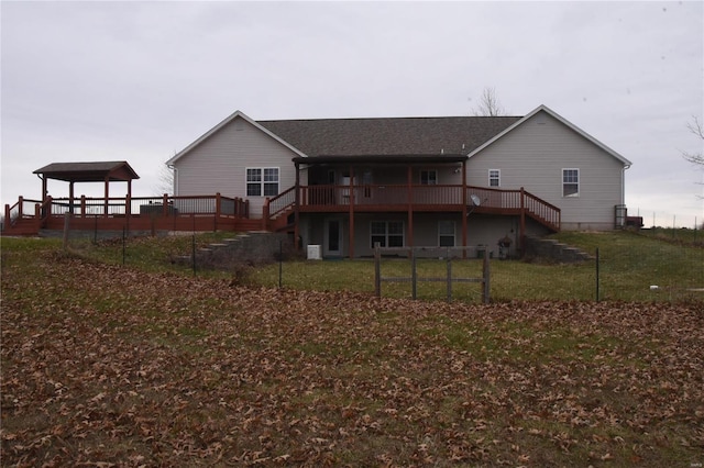 back of house featuring a deck and a lawn