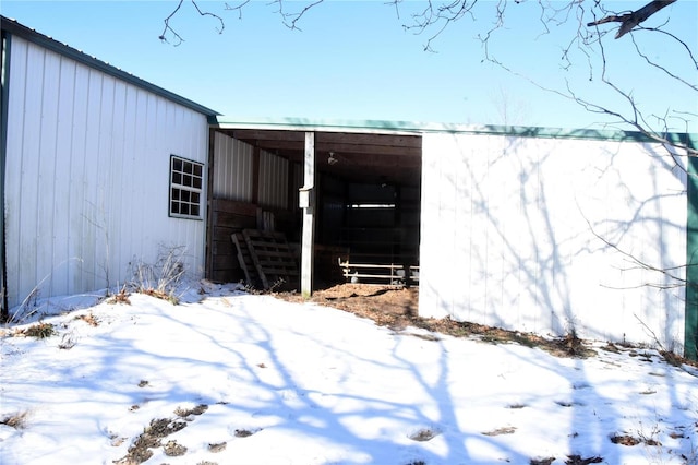 snow covered property featuring an outdoor structure