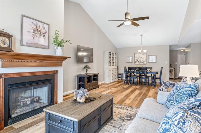 living room with high vaulted ceiling, ceiling fan, and light hardwood / wood-style floors