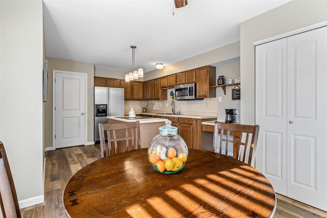 dining space featuring sink and dark wood-type flooring