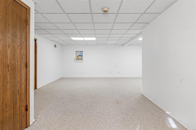 carpeted spare room featuring a paneled ceiling