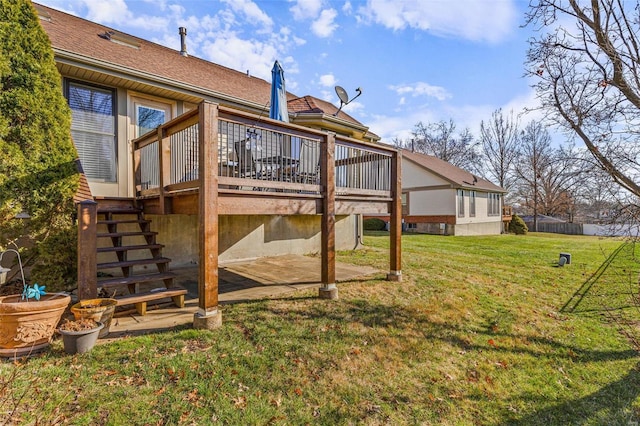 rear view of house with a patio, a wooden deck, and a lawn