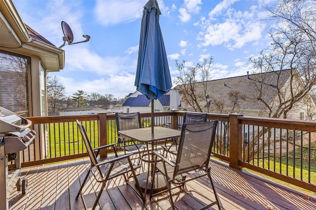 wooden deck featuring a lawn and grilling area