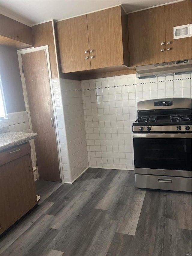 kitchen with dark hardwood / wood-style flooring, ventilation hood, and stainless steel range with gas stovetop