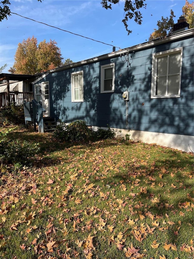 view of side of property featuring a lawn and a deck