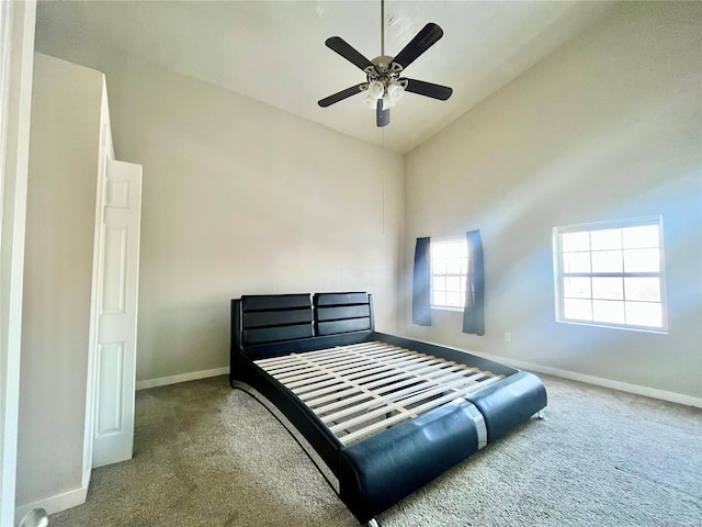 carpeted bedroom with ceiling fan and high vaulted ceiling