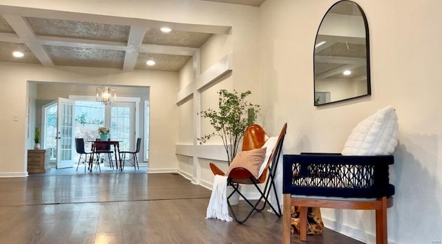 interior space with beamed ceiling, dark hardwood / wood-style floors, an inviting chandelier, and coffered ceiling