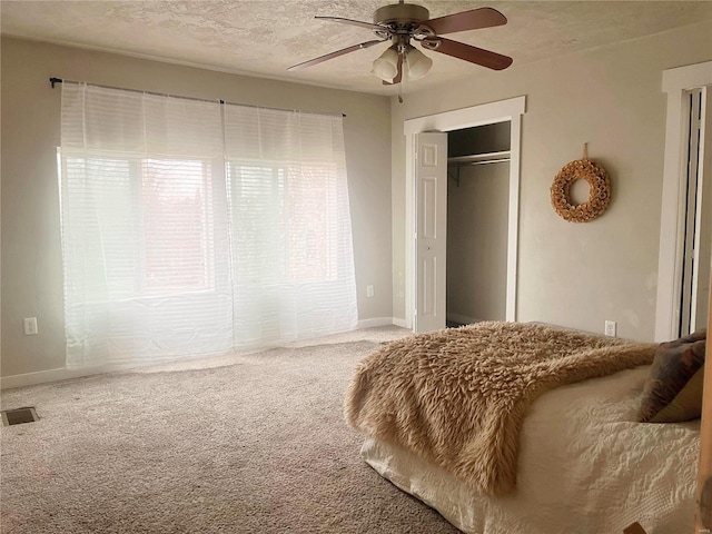 carpeted bedroom with a textured ceiling, a closet, and ceiling fan