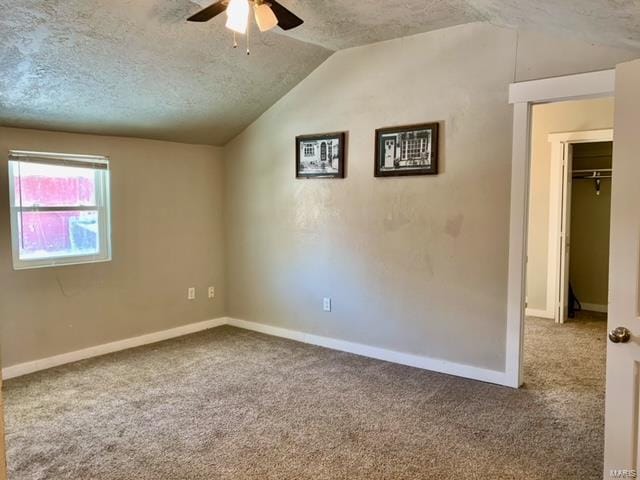 empty room featuring carpet flooring, ceiling fan, a textured ceiling, and vaulted ceiling