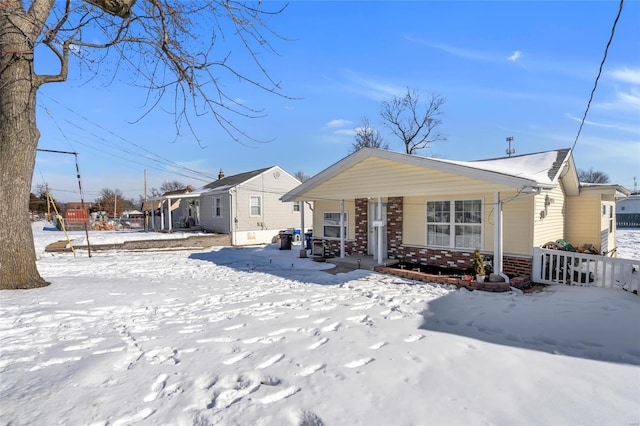 snow covered rear of property with covered porch