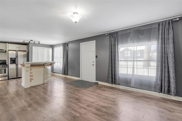 kitchen featuring a kitchen breakfast bar, appliances with stainless steel finishes, and light wood-type flooring