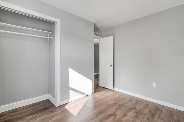 unfurnished bedroom featuring a closet and hardwood / wood-style flooring