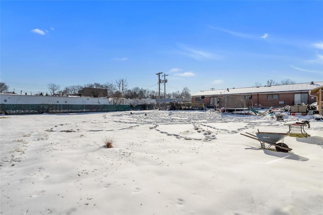 yard covered in snow with a trampoline