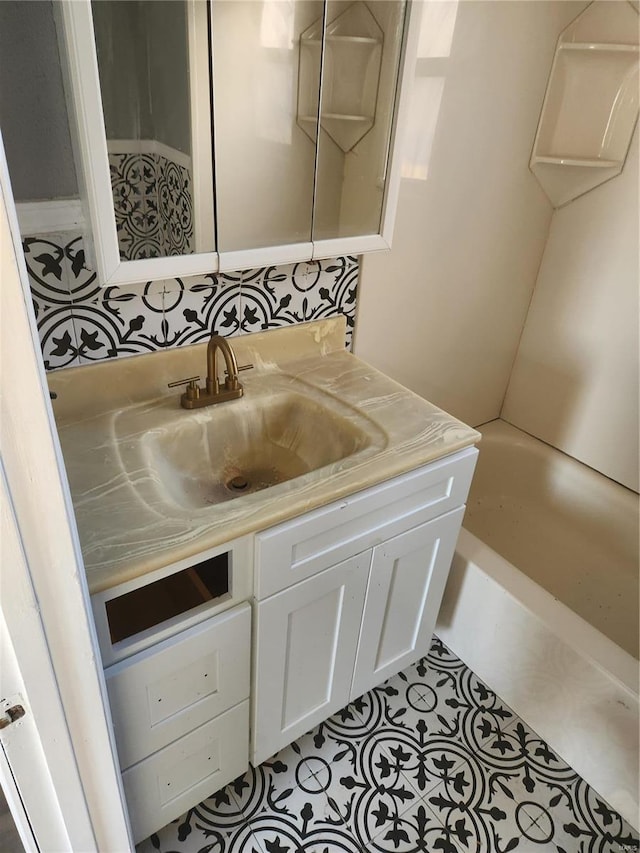 bathroom with tile patterned flooring, vanity, and a washtub