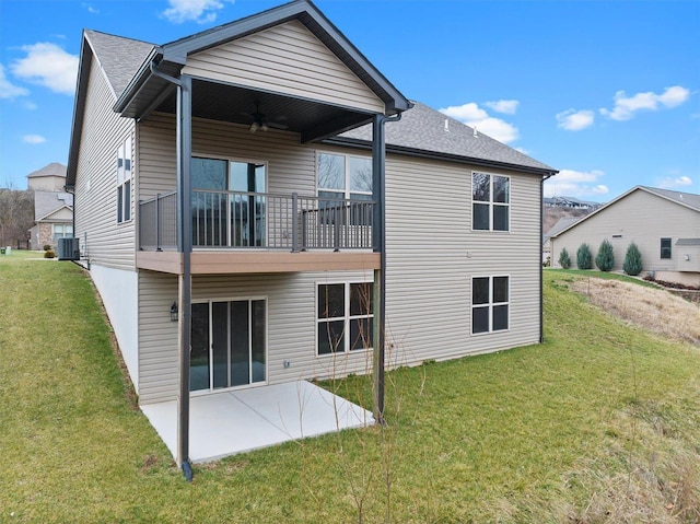 rear view of house featuring central air condition unit, ceiling fan, a balcony, a yard, and a patio area