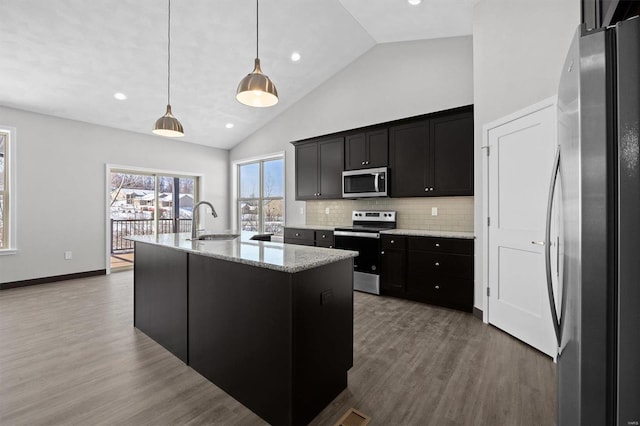 kitchen with backsplash, sink, an island with sink, decorative light fixtures, and stainless steel appliances