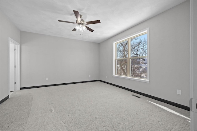 empty room with ceiling fan and light carpet