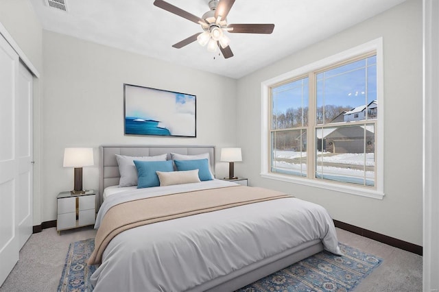 carpeted bedroom featuring ceiling fan and a closet