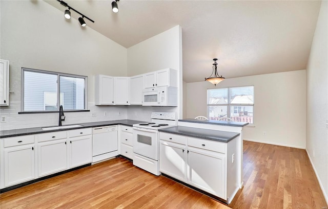 kitchen with pendant lighting, white appliances, white cabinets, sink, and kitchen peninsula