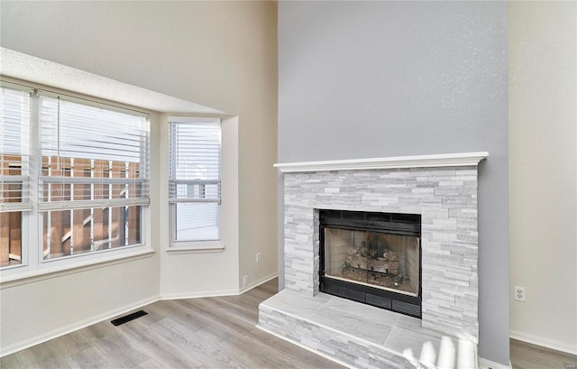 interior details featuring a tiled fireplace and hardwood / wood-style flooring