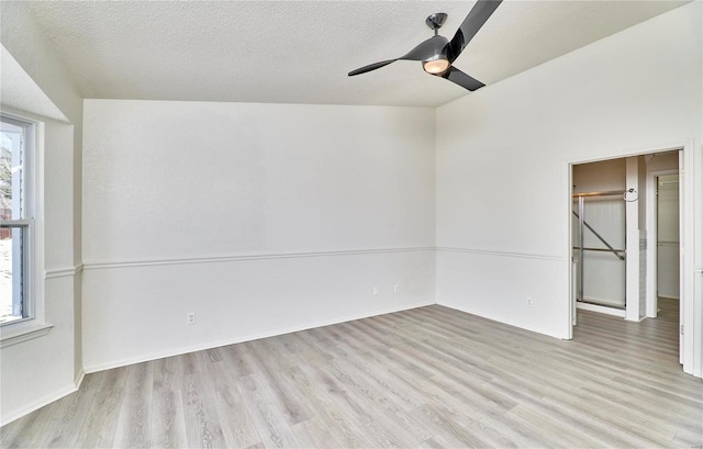 unfurnished room featuring ceiling fan, light hardwood / wood-style floors, and a textured ceiling