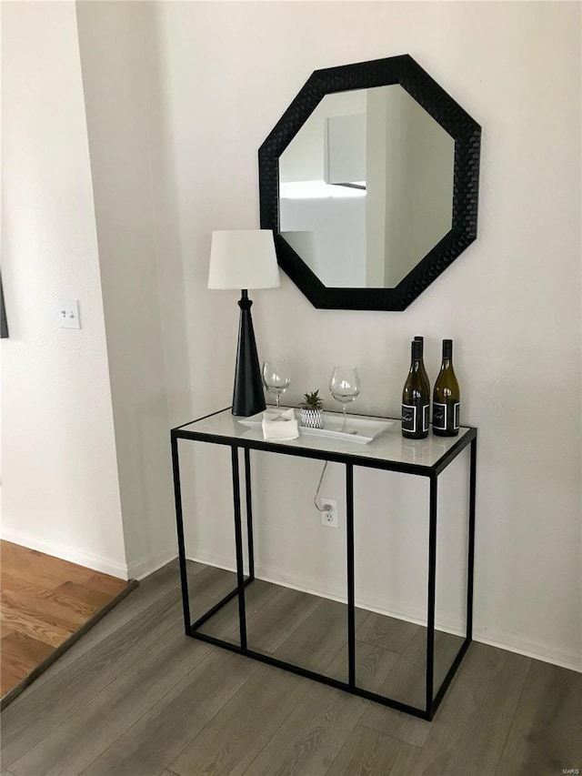 room details with a bar, wood finished floors, and baseboards