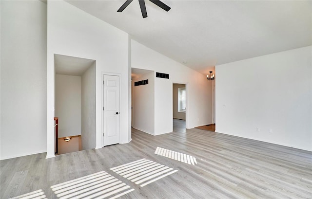 unfurnished room featuring light wood-style floors, a ceiling fan, visible vents, and high vaulted ceiling