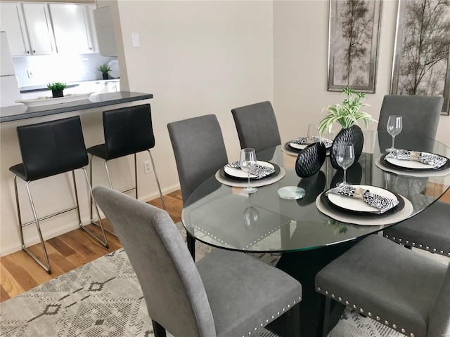 dining space with wood finished floors and baseboards