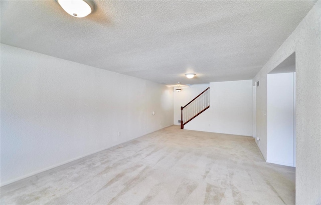 basement with stairs, a textured ceiling, and carpet flooring