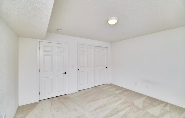 unfurnished bedroom featuring a textured ceiling, carpet floors, and a closet