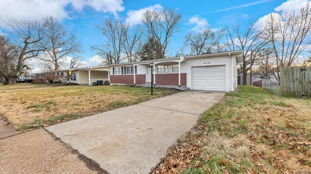 ranch-style home featuring a garage and a front lawn