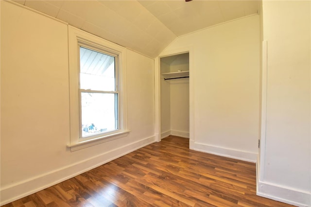 unfurnished bedroom with dark hardwood / wood-style floors, a closet, and vaulted ceiling