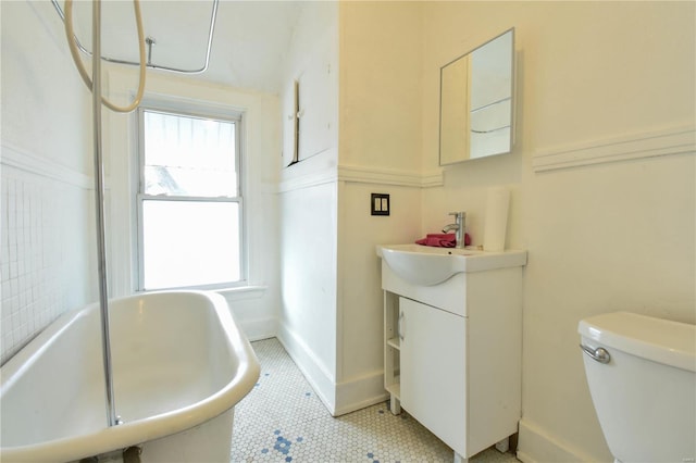 bathroom with tile patterned floors, vanity, a bath, and toilet