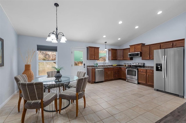 kitchen featuring a healthy amount of sunlight, stainless steel appliances, sink, and hanging light fixtures