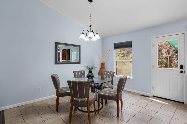 dining area with light tile patterned flooring, lofted ceiling, and an inviting chandelier