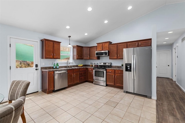 kitchen featuring pendant lighting, sink, light tile patterned floors, stainless steel appliances, and high vaulted ceiling