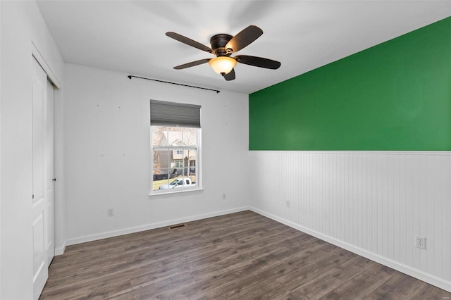 unfurnished bedroom featuring dark wood-type flooring, ceiling fan, and a closet