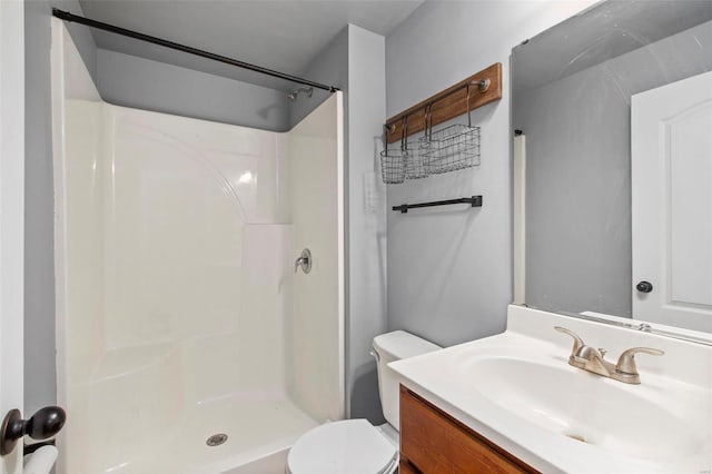 bathroom with vanity, a shower, and toilet