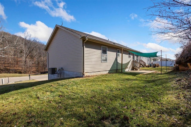 view of home's exterior featuring central air condition unit and a lawn