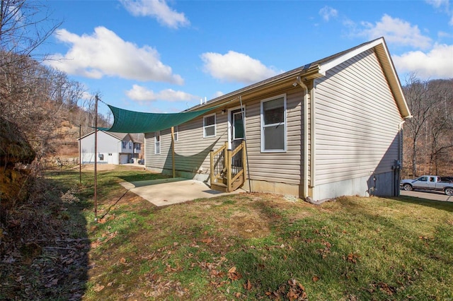 back of property with a lawn and a patio