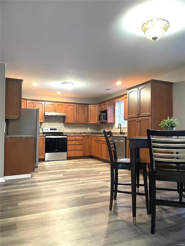 kitchen featuring sink, refrigerator, light hardwood / wood-style flooring, and stainless steel electric range