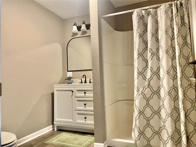 bathroom featuring toilet, wood-type flooring, vanity, and a shower with curtain