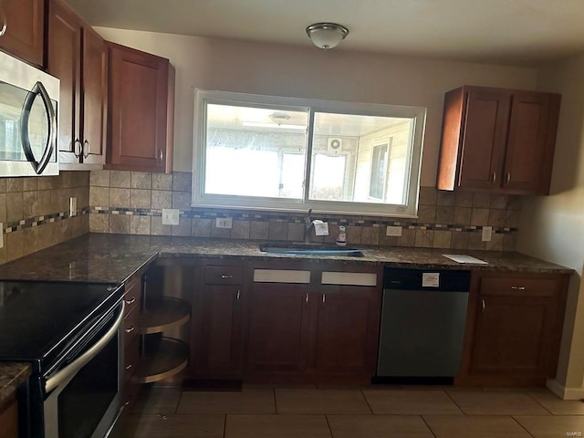 kitchen featuring dark stone countertops, sink, stainless steel appliances, and tile patterned flooring