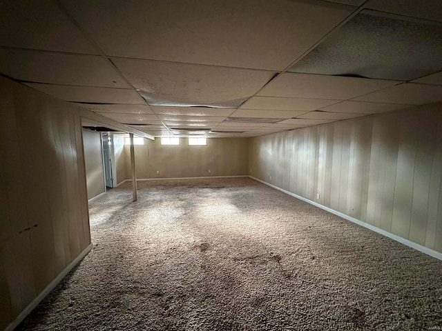 basement featuring carpet flooring and a paneled ceiling