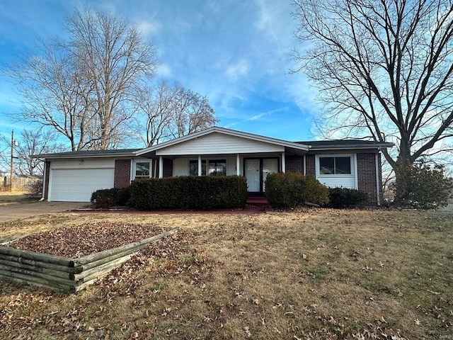 single story home featuring a porch, a front yard, and a garage