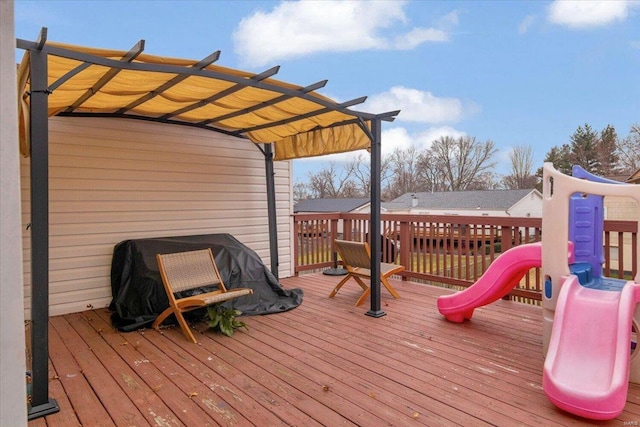 wooden deck featuring area for grilling and a pergola