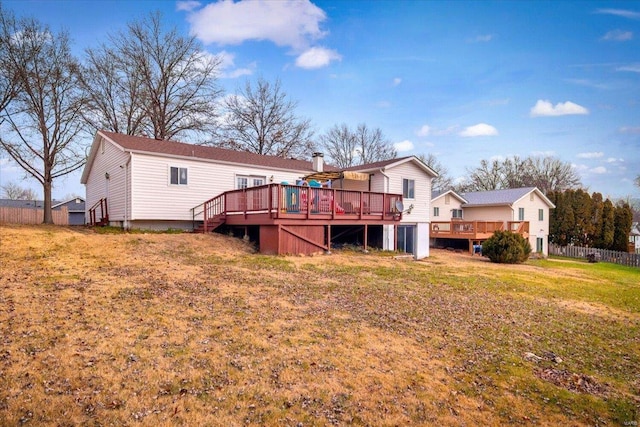 back of property with a wooden deck and a yard