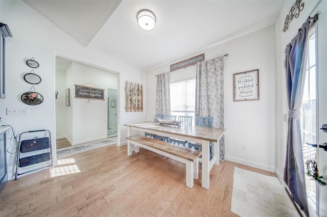 dining room featuring vaulted ceiling and light wood-type flooring